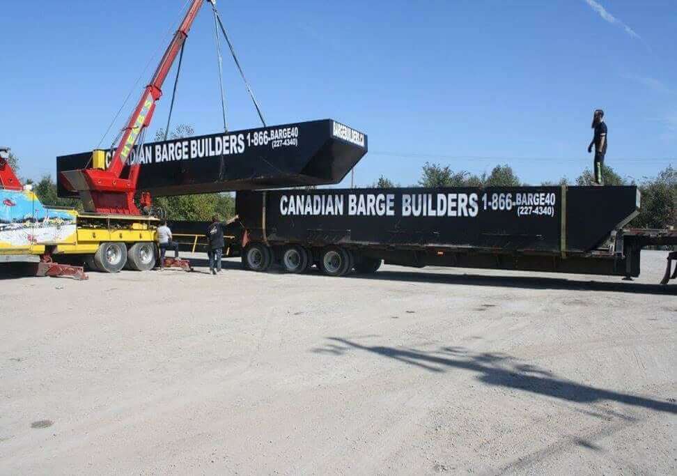 barge builders - image of barges being moved by a crane in yard.jpg